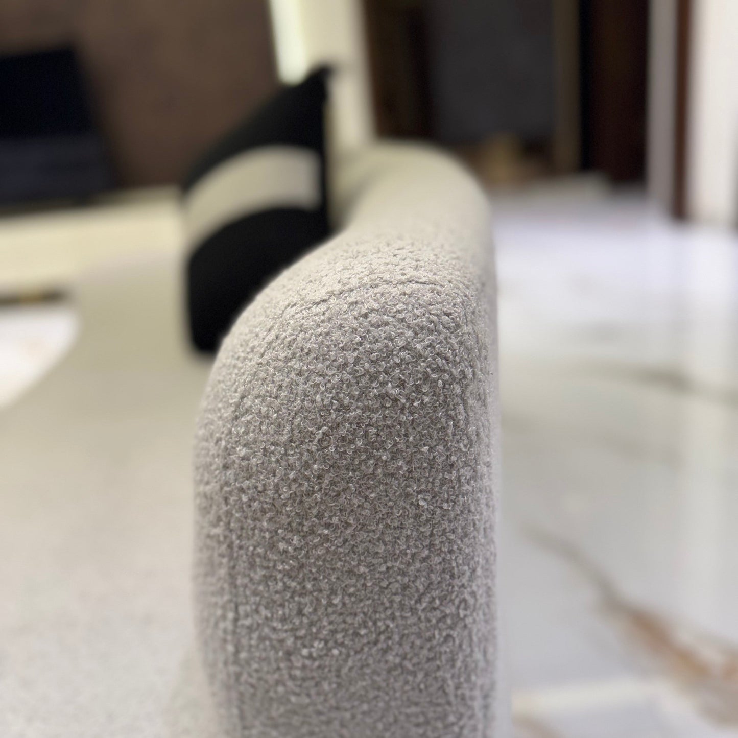 Grey couch in a well-lit living room with a black ceiling fan and modern lighting.