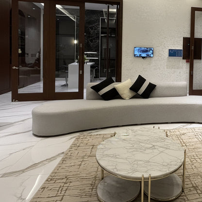 Modern living room with a grey couch and marble coffee tables.