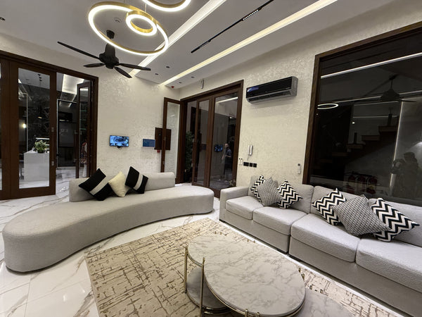 Modern living room with a grey couch and marble coffee tables.