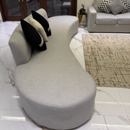 Elegant living room with a grey couch, dark curtains, and a textured rug.