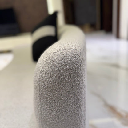 Grey couch in a well-lit living room with a black ceiling fan and modern lighting.