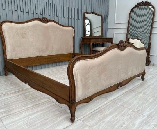 An elegant bed set featuring a wooden frame and upholstered headboard, accompanied by matching furniture.