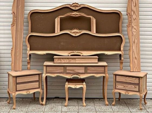 A wooden Baroque-style bedroom set, including a bed frame, nightstands, and a dressing table.
