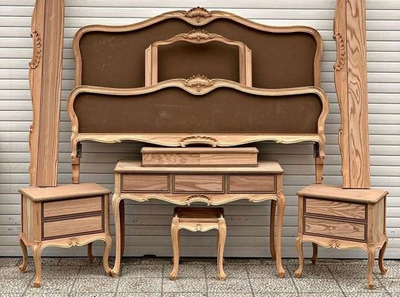 A wooden Baroque-style bedroom set, including a bed frame, nightstands, and a dressing table.