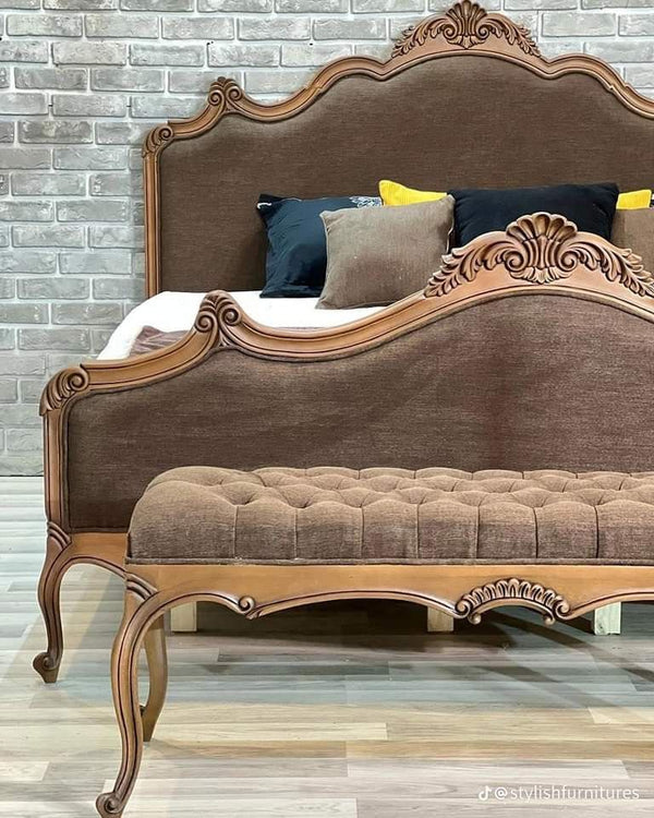 An ornate Aurora Baroque Bed Frame with a cream-colored tufted headboard and gold detailing.