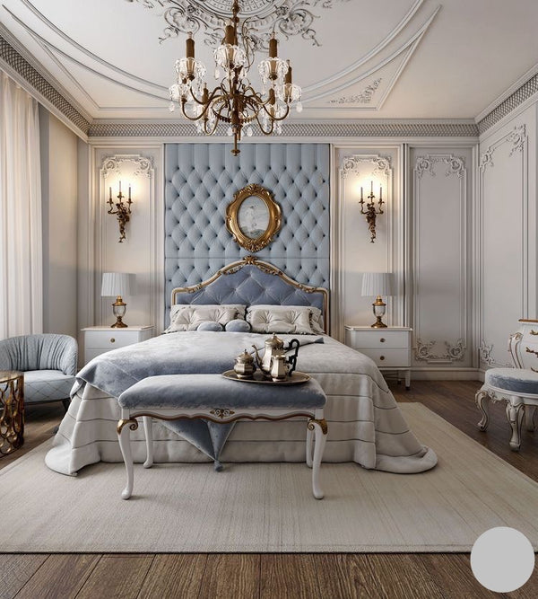 Elegant bedroom with a prominent light blue tufted headboard bed, ornate gold chandelier, and classic white furniture.