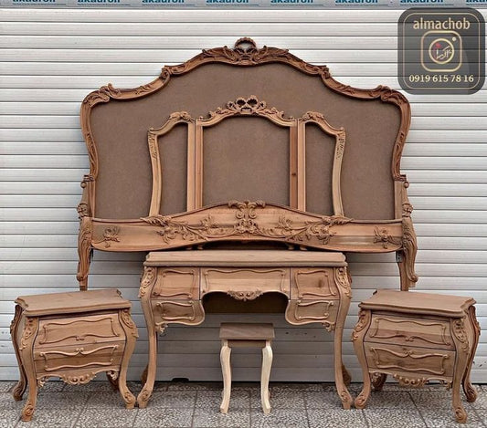 A wooden Akfa KFA Bed with a carved headboard side tables and dresser.