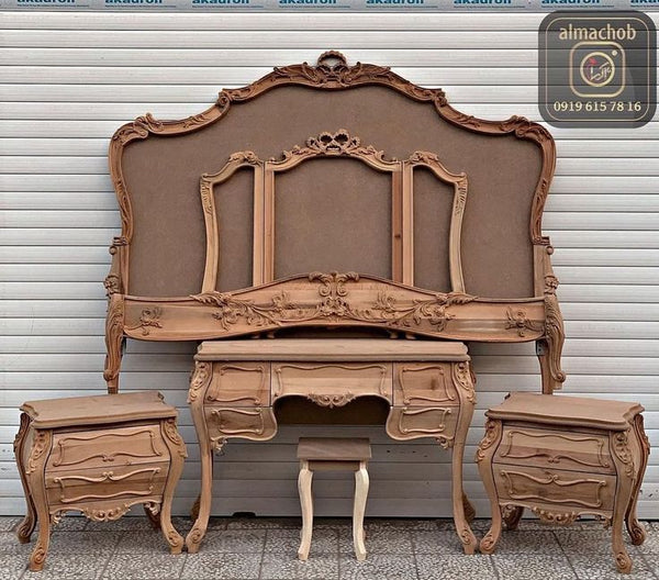 A wooden Akfa KFA Bed with a carved headboard side tables and dresser.